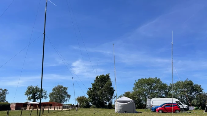 Grantham Amateur Radio Club members operating portable amateur radio stations with HF and VHF antennas during a sunny field day in Lincolnshire.